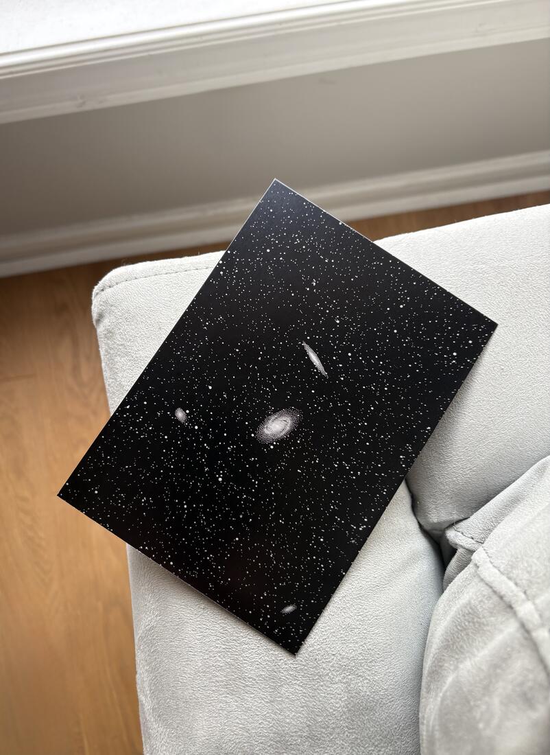 Astrophotography engraving of the M81 and M82 galaxies in a dense star field on matte black aluminum