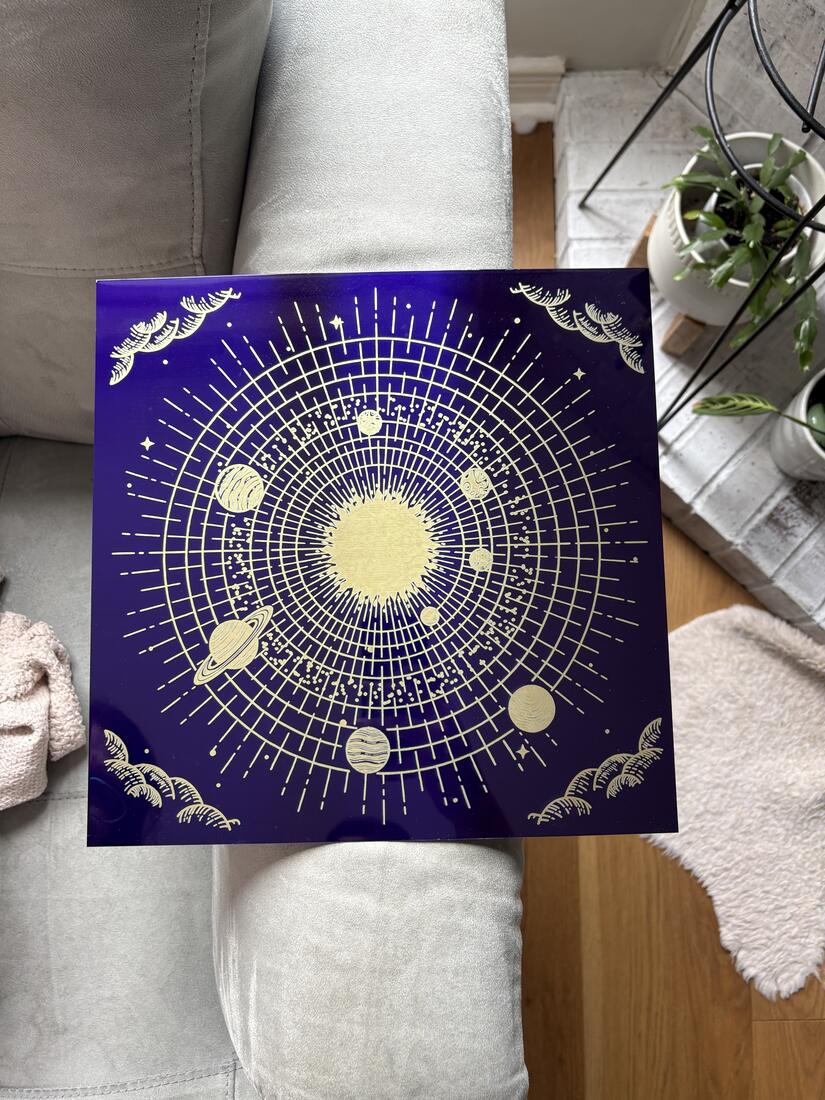 Solar system orrery design engraved in gold on deep violet anodized aluminum